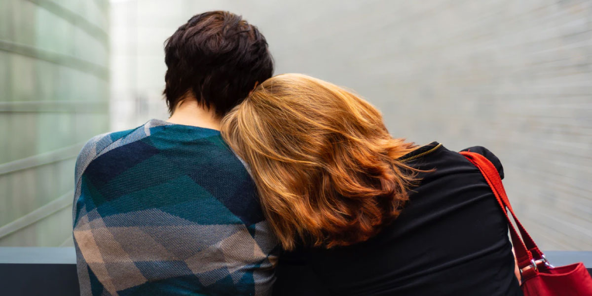 woman leaning her head on man's shoulder