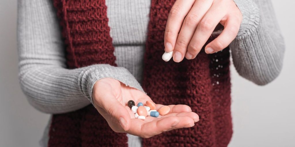 Person holding a handful of pills