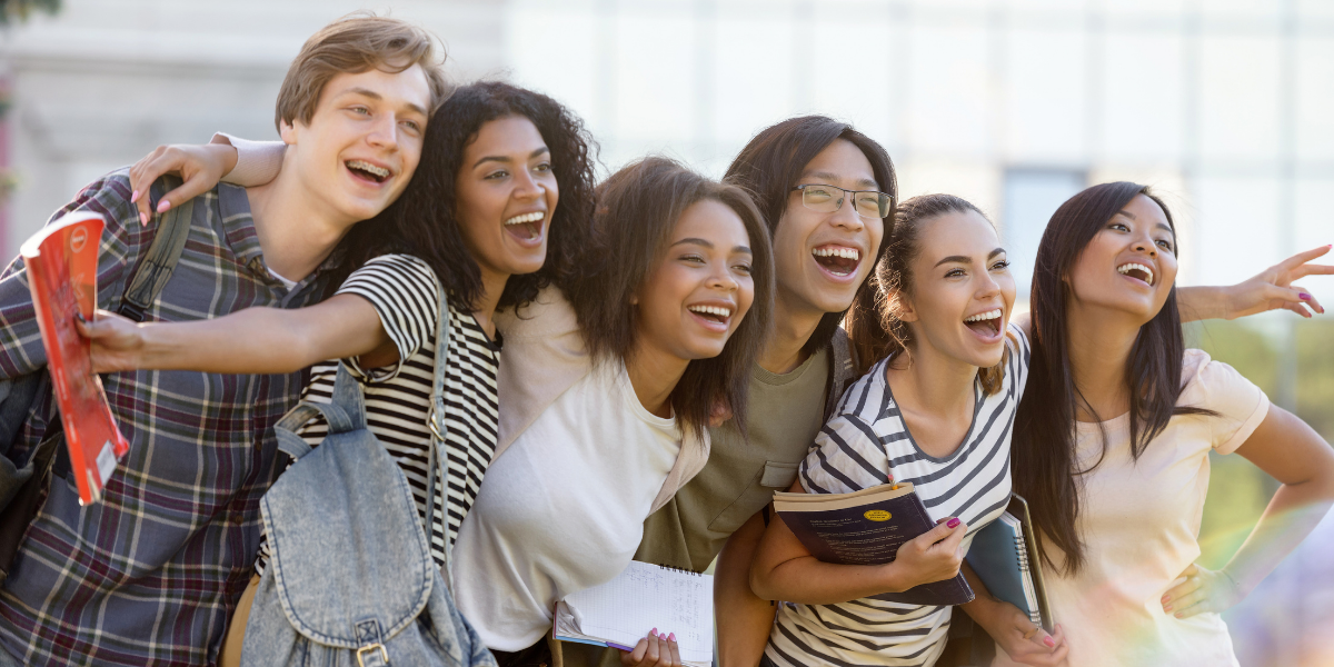 group of happy college students standing outdoors