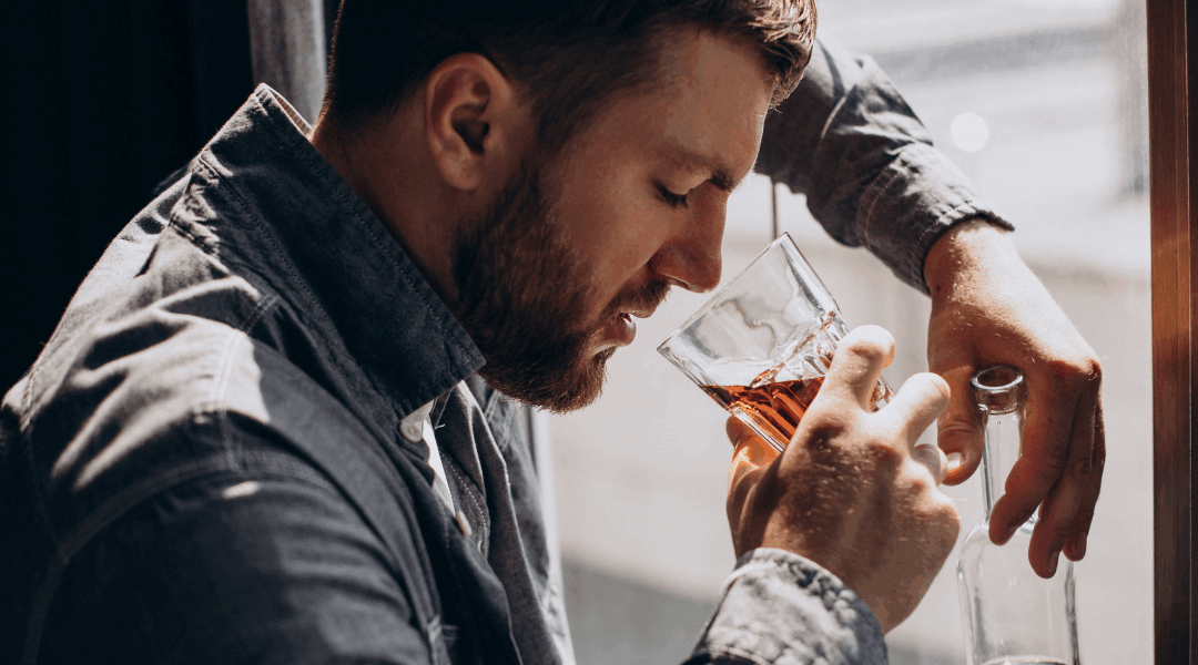 Man drinker depressed with bottle of whiskey