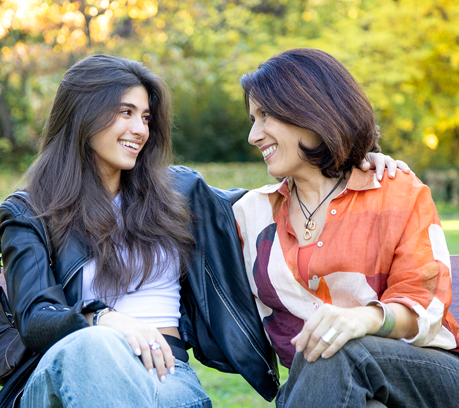 mother and daughter sitting on a bench enjoying free time and good weather